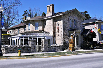 The historic stone home property known as the Breadalbane Inn in downtown Fergus is home to two restaurants, Scozia and the Fergusson Room pub. The exterior of the two-storey building is stone with a large rock-wall fence around an outdoor patio along the west side of the property, closed in with wrought iron gates. A large solarium overlooks the patio. Out front of the Breadalbane Inn is a large wooden stage of a man in a kilt holding up a sword, carved from a former tree on the property.